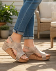 Beige distressed leather open-toe wedge sandals with ankle strap and studs