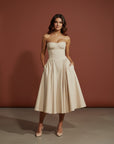 Cream fitted midi dress with adjustable spaghetti straps and pleated flared skirt