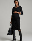 Black maternity midi dress with ruched waist and 3/4 sleeves, fitted silhouette.