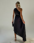 Dark pleated one-shoulder maxi dress with diagonal back strap and asymmetrical hem