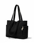 Corduroy tote bag in black with ribbed texture, two top handles, and front pocket