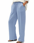 Light blue wide-leg linen pants with elastic waist and drawstring ties, relaxed full-length fit.