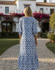 Back view of flowing blue-and-white patterned maxi dress with 3/4 sleeves