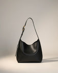 Black slouchy shoulder bag with gold-tone buckle strap