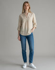 Light beige linen blouse with V-neck and partial button placket, rolled three-quarter sleeves.