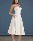 Off-white fitted midi dress with adjustable spaghetti straps and gathered flared skirt