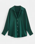 Deep green long-sleeve blouse on hanger with button front and pointed collar