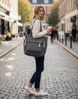 Grey corduroy tote bag with tassel accents and wide shoulder strap