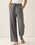 Gray wide-leg linen pants with elastic waist and drawstring ties, relaxed straight silhouette.