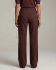 High-waist tailored trousers in deep plum with crease lines and front button closure