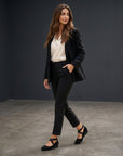 Black wedge ballet flats with crisscross straps and low heel, slip-on style.