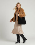 Black soft textured shoulder bag with wide open top and short handles.