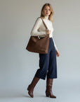 Brown suede-look shoulder bag with open top and short handles.