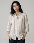 Cream striped button-up blouse with chest pocket and rolled sleeves, blue vertical lines.