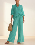 Teal button-front blouse and wide-leg trousers set with rolled sleeves
