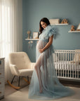 Light blue sheer tulle maternity gown with off-shoulder bodice and feathered sleeve