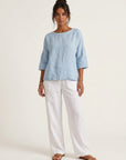 White wide-leg linen pants with elastic waistband and drawstring, full-length relaxed fit.
