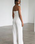 White strapless jumpsuit with wide legs and belt tie, side view