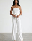 White strapless wide-leg jumpsuit with bow at the waist, front view