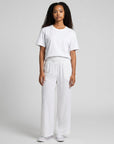 White smocked high-waist wide-leg pants with gathered elastic waistband