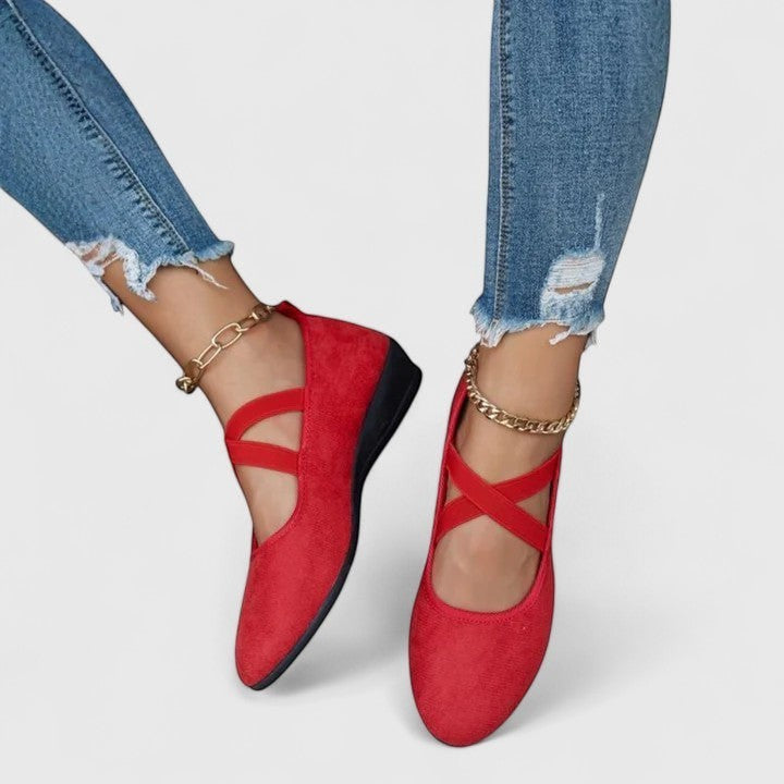Red wedge ballet flats with ankle strap and cross straps, closed toe.