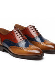 Men's leather wingtip brogue shoes, cognac red and blue colorblock, lace-up.