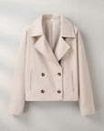Beige double-breasted jacket with pointed lapels, four-button front, and flap pockets