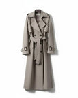 Taupe trench coat with double-breasted buttons, belted waist, and flap shoulder accents.