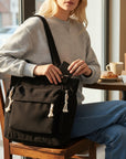 Dark corduroy tote bag with tassel zipper pulls and front pocket