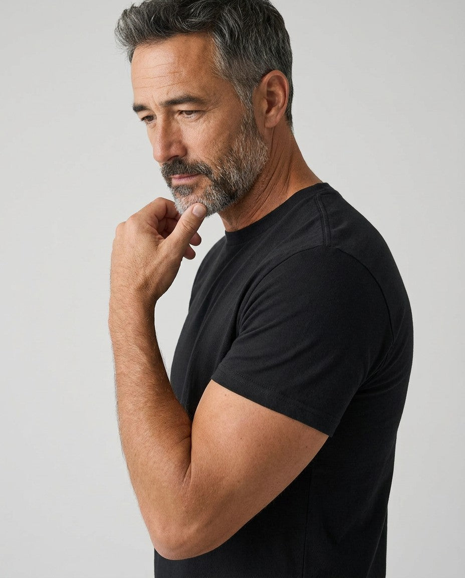 Men's black crew-neck T-shirt, short sleeves, side view with hand at collar.