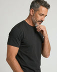 Men's black crew-neck T-shirt detail, short sleeve and neckline from side.