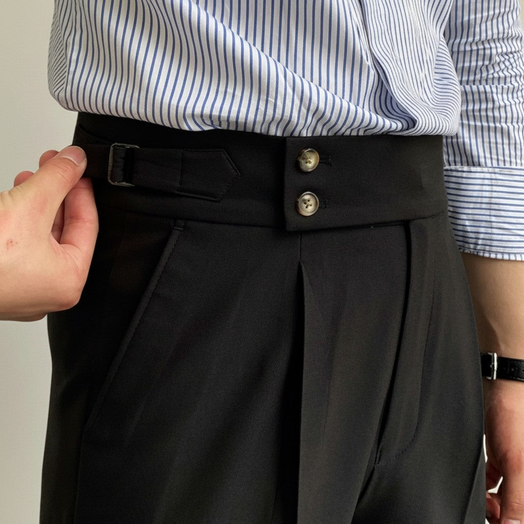 Men's high-waisted straight-leg tailored trousers in black, close-up of waistband buttons