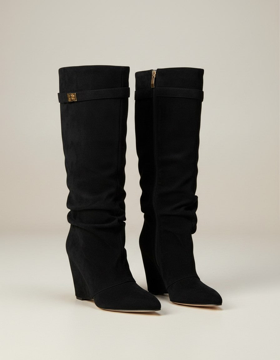 Black knee-high slouch boots with gold buckle tab at top shaft