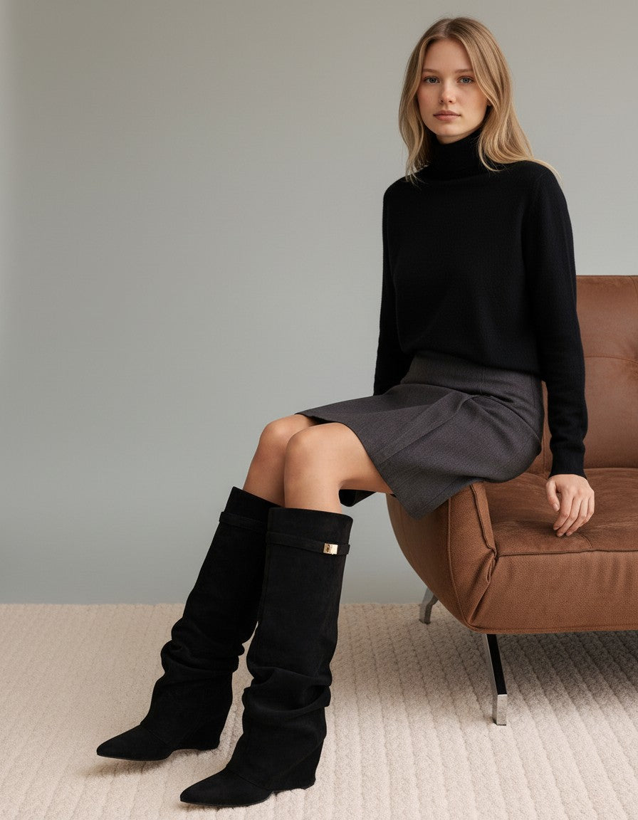 Black knee-high slouch boots on model, flat sole, gold buckle at cuff