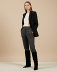 Black knee-high slouch boots with gold buckle, worn with dark trousers