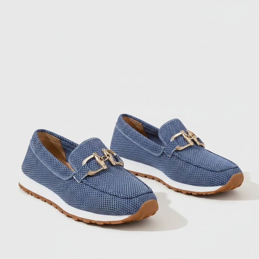 Pair of blue slip-on loafers with gold bit hardware and tan rubber outsole.