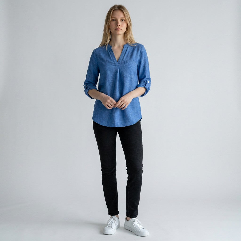 Blue linen blouse with V-neck and button placket, three-quarter sleeves folded at cuffs.