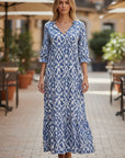 Flowing blue-and-white maxi dress with V-neck, 3/4 sleeves, tiered skirt