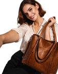Cognac leather tote bag with curved strap and zip pocket at front