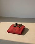 Cropped red knit cardigan with leather-like collar, centered zipper, ribbed cuffs