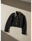 Cropped black knit cardigan with leather-like pointed collar, gold zip, ribbed cuffs