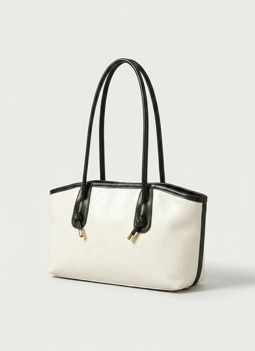 Off-white tote bag with black handles and subtle trim