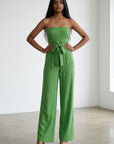 Green strapless wide-leg jumpsuit with tied waist and fitted bodice, front view