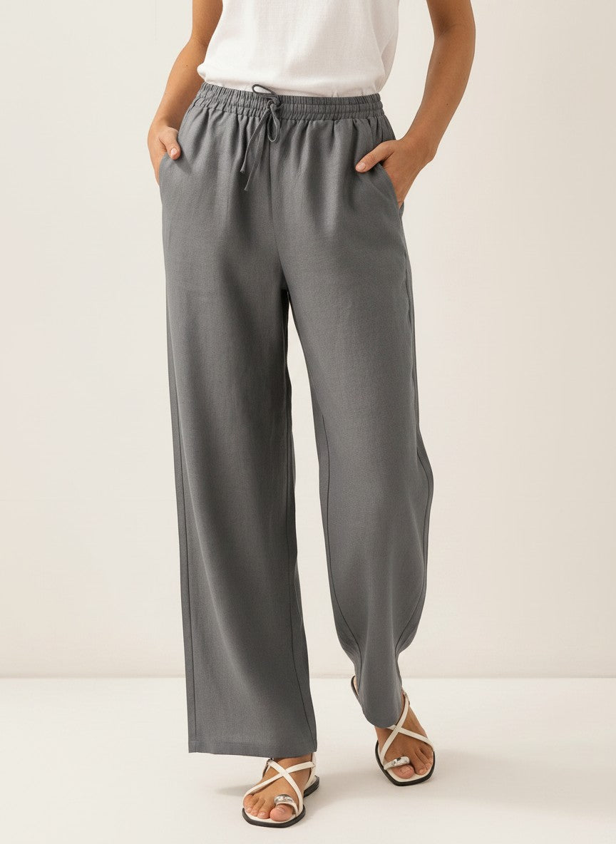 Gray wide-leg linen pants with elastic waist and drawstring ties, relaxed straight silhouette.