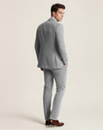 Grey tweed three-piece suit shown in side view: blazer, vest, and slim-fit trousers