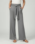 Grey relaxed wide-leg trousers with tie waist and draped front.