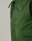 Men's green cargo shorts close-up of drawstring waist and side pocket