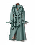 Green trench coat with belted waist, double-breasted buttons, and shoulder epaulets.