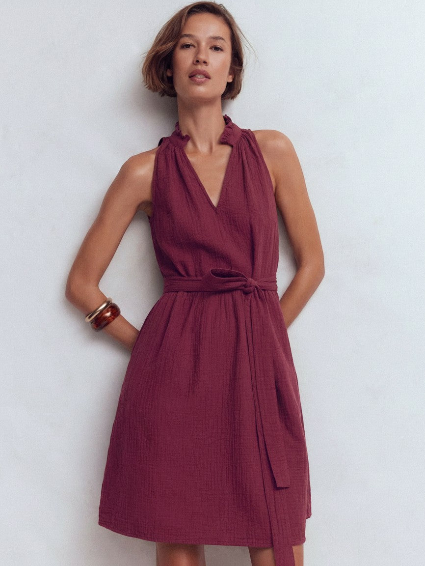 Sleeveless short dress with V-neck, gathered bodice, and tie waist in burgundy