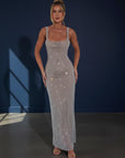 Embellished evening gown with square neckline, sleeveless straps, and long column fit in silver.